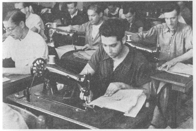 “Men operating sewing machines in a collectivized factory.”