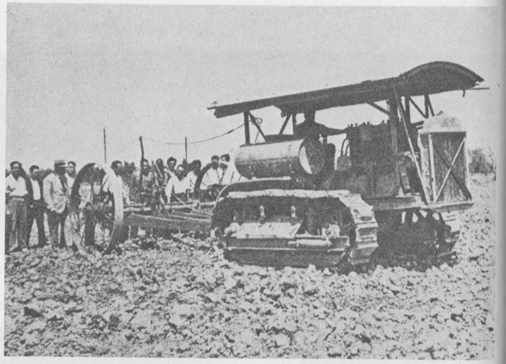 “Farmers with a new mechanized tractor on a collectivized farm.”